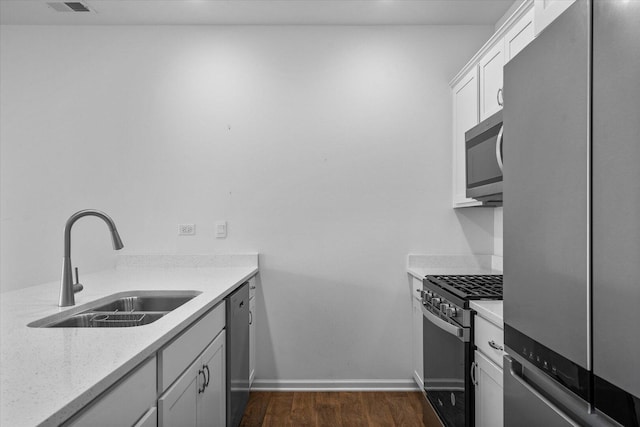 927 Darwin St, North Aurora, IL 60542 - kitchen with appliances with stainless steel finishes, dark wood-style flooring, and white cabinets