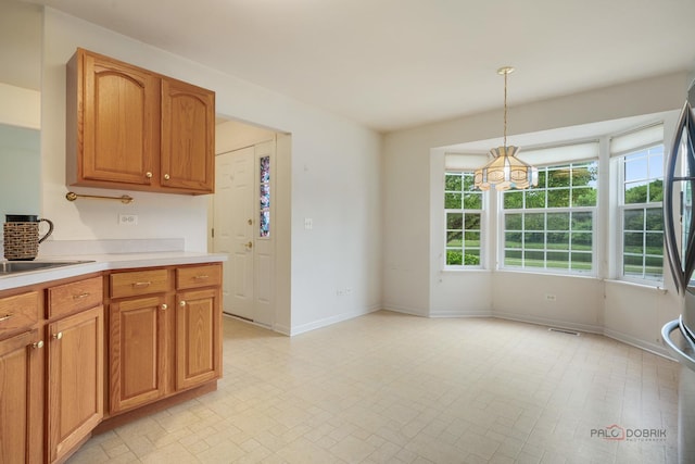 707 Wedgewood Trl, Mchenry, IL 60050 - kitchen featuring light countertops, a chandelier, decorative light fixtures, and brown cabinets