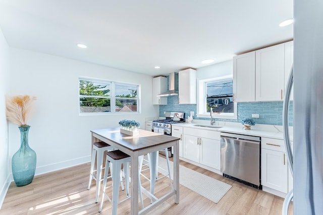 3020 77th Ave, Elmwood Park, IL 60707 - kitchen featuring stainless steel appliances, wall chimney exhaust hood, light wood-type flooring, backsplash, and recessed lighting