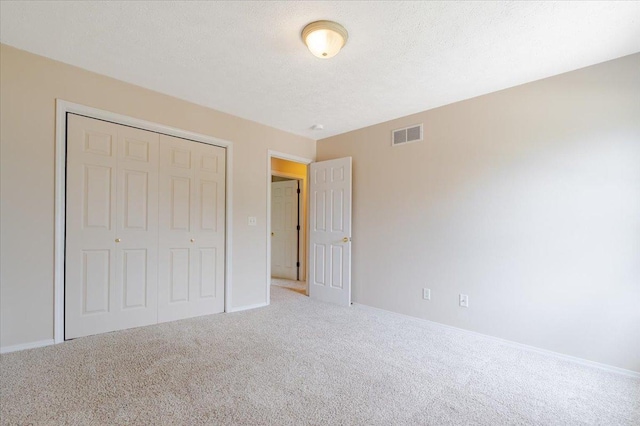 3310 Stonebridge Dr, Bloomington, IL 61704 - unfurnished bedroom featuring carpet, a closet, and a textured ceiling