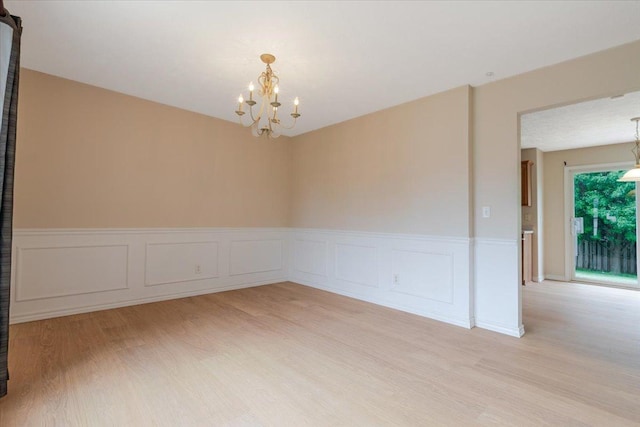3310 Stonebridge Dr, Bloomington, IL 61704 - empty room with a chandelier, light wood-style flooring, and wainscoting