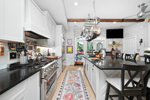 1530 W Monroe St, Chicago, IL 60607 - kitchen featuring premium appliances, a breakfast bar area, beam ceiling, backsplash, and custom exhaust hood