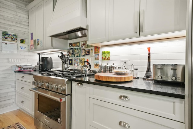 1530 W Monroe St, Chicago, IL 60607 - kitchen featuring high end range, premium range hood, backsplash, and dark countertops