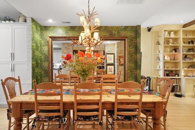 1530 W Monroe St, Chicago, IL 60607 - dining room featuring wallpapered walls, a chandelier, light wood-style floors, and an accent wall