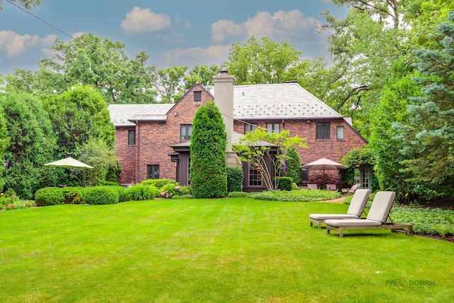 670 S Green Bay Rd, Lake Forest, IL 60045 - view of front facade with a high end roof, a chimney, a front lawn, and brick siding