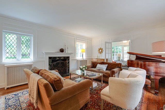 670 S Green Bay Rd, Lake Forest, IL 60045 - living room with a decorative wall, radiator, wood finished floors, a high end fireplace, and crown molding