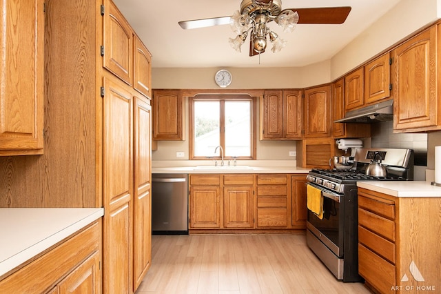 421 W Verret St, Elmhurst, IL 60126 - kitchen featuring stainless steel appliances, under cabinet range hood, a ceiling fan, light countertops, and brown cabinetry