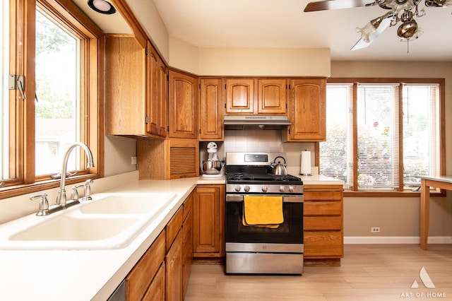421 W Verret St, Elmhurst, IL 60126 - kitchen featuring stainless steel gas stove, under cabinet range hood, a ceiling fan, light wood finished floors, and brown cabinets