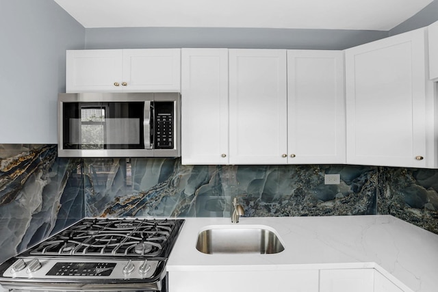 4880 N Marine Dr Unit 404, Chicago, IL 60640 - kitchen featuring appliances with stainless steel finishes, white cabinetry, and tasteful backsplash