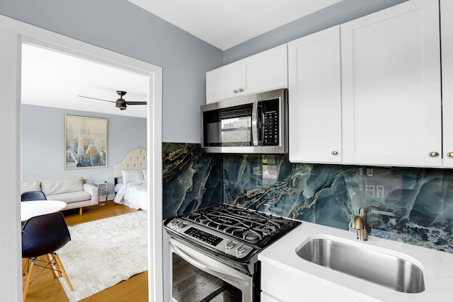 4880 N Marine Dr Unit 404, Chicago, IL 60640 - kitchen with appliances with stainless steel finishes, backsplash, white cabinets, and ceiling fan