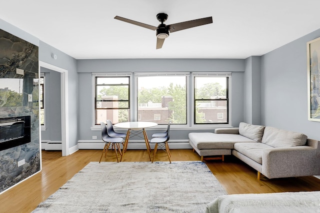 4880 N Marine Dr Unit 404, Chicago, IL 60640 - living area featuring a baseboard radiator, ceiling fan, a premium fireplace, and wood finished floors