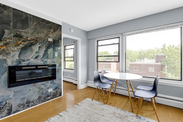 4880 N Marine Dr Unit 404, Chicago, IL 60640 - dining space with a baseboard radiator, wood finished floors, and a large fireplace