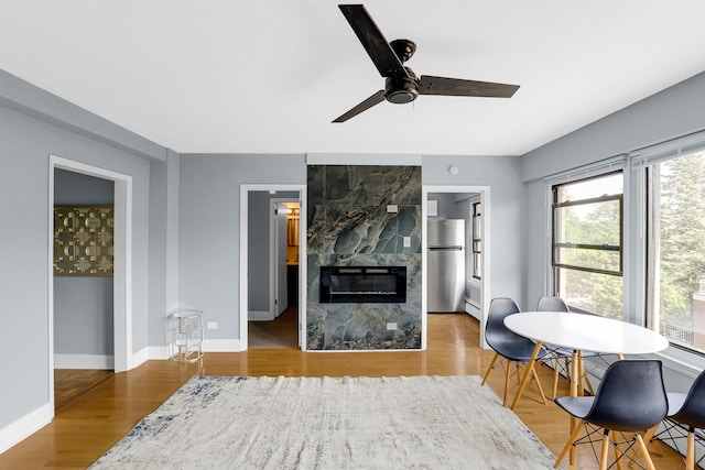 4880 N Marine Dr Unit 404, Chicago, IL 60640 - living area featuring ceiling fan, a tile fireplace, baseboard heating, and wood finished floors