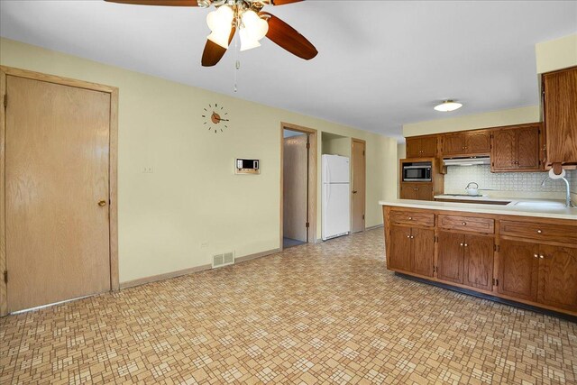 11340 S Drake Ave, Chicago, IL 60655 - kitchen with freestanding refrigerator, stainless steel microwave, under cabinet range hood, light countertops, and ceiling fan