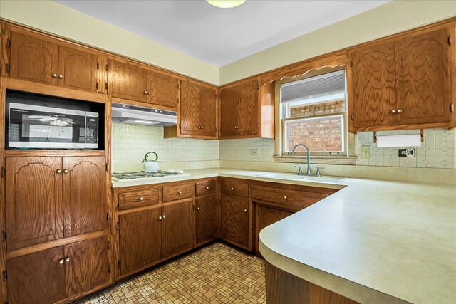 11340 S Drake Ave, Chicago, IL 60655 - kitchen featuring stainless steel microwave, extractor fan, light countertops, gas stovetop, and tasteful backsplash