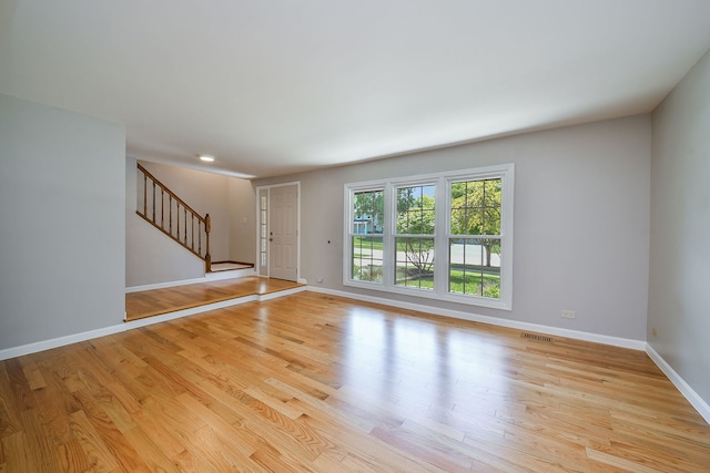 27W098 Walnut Dr, Winfield, IL 60190 - unfurnished living room featuring stairway and light wood-style floors