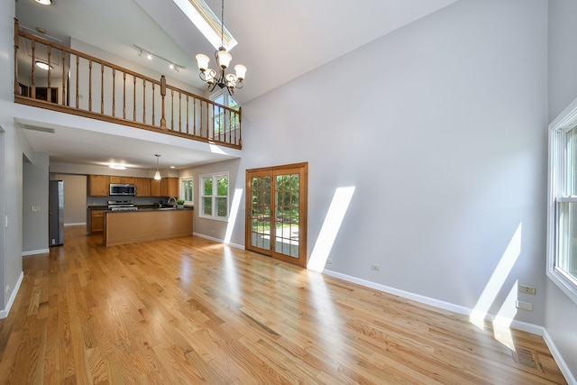 27W098 Walnut Dr, Winfield, IL 60190 - unfurnished living room with high vaulted ceiling, light wood-type flooring, and a chandelier