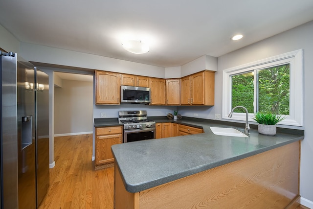 27W098 Walnut Dr, Winfield, IL 60190 - kitchen featuring stainless steel appliances, a peninsula, dark countertops, light wood-style floors, and brown cabinets