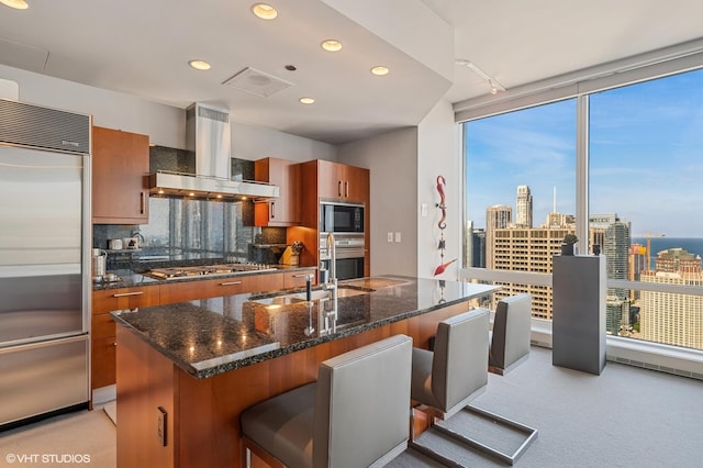 401 N Wabash Ave Unit 33K, Chicago, IL 60611 - kitchen with built in appliances, wall chimney range hood, brown cabinets, a kitchen breakfast bar, and expansive windows