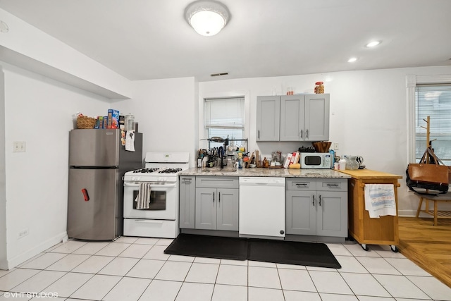 2076 N Campbell Ave, Chicago, IL 60647 - kitchen with white appliances, gray cabinets, recessed lighting, and light tile patterned floors