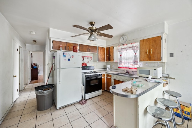 15620 Ingleside Ave, Dolton, IL 60419 - kitchen featuring white appliances, a peninsula, brown cabinetry, and decorative backsplash