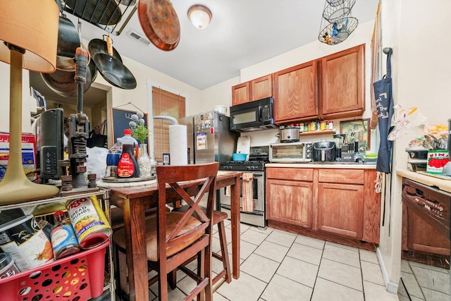 1516 E 74th Pl, Chicago, IL 60619 - kitchen featuring black microwave, stainless steel gas range, brown cabinets, and light tile patterned floors
