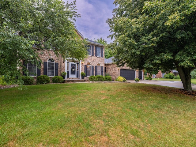 15955 Raintree Rd, Bloomington, IL 61705 - view of front of house featuring a front lawn, concrete driveway, stone siding, and brick siding