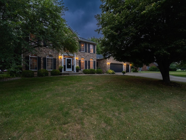 15955 Raintree Rd, Bloomington, IL 61705 - colonial inspired home with stone siding, a front yard, driveway, and a garage