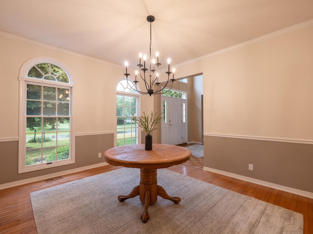 15955 Raintree Rd, Bloomington, IL 61705 - dining room with a chandelier, plenty of natural light, wood finished floors, and ornamental molding