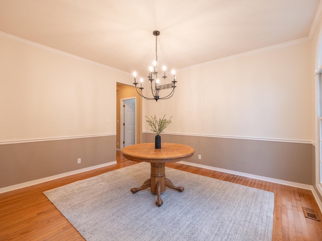 15955 Raintree Rd, Bloomington, IL 61705 - dining space with a chandelier, light wood-type flooring, and crown molding