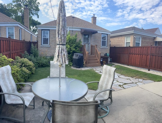 7641 W Hortense Ave, Chicago, IL 60631 - rear view of property featuring brick siding, a fenced backyard, outdoor dining area, and a patio area
