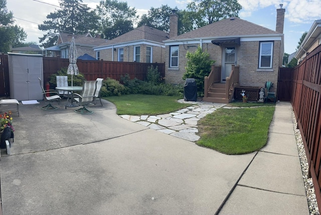 7641 W Hortense Ave, Chicago, IL 60631 - rear view of house with brick siding, a patio area, a fenced backyard, and a chimney