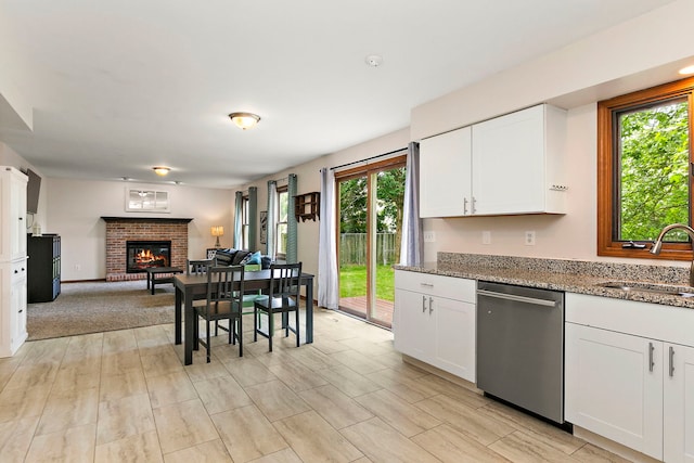 219 N Nina St, Cortland, IL 60112 - kitchen featuring stainless steel dishwasher, plenty of natural light, a fireplace, and white cabinetry