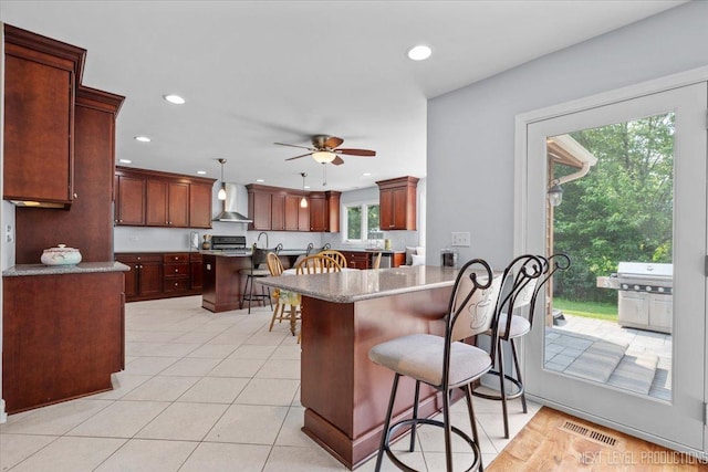 978 Merrimac Cir, Naperville, IL 60540 - kitchen featuring wall chimney exhaust hood, a kitchen bar, stove, recessed lighting, and light tile patterned flooring