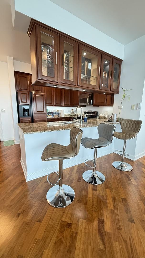 1841 S Calumet Ave Unit 2102, Chicago, IL 60616 - bar with stainless steel microwave and dark wood finished floors
