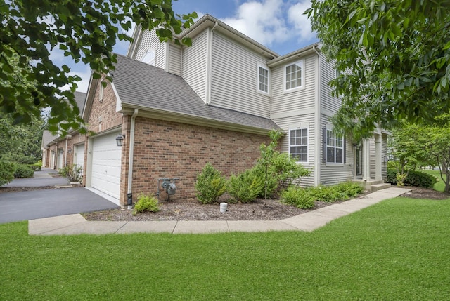1850 Maureen Dr, Hoffman Estates, IL 60192 - view of side of home with a yard, a garage, brick siding, asphalt driveway, and roof with shingles