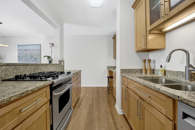1315 W Webster Ave, Chicago, IL 60614 - kitchen featuring stainless steel appliances, light stone counters, light wood-style floors, light brown cabinets, and glass insert cabinets