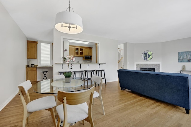1315 W Webster Ave, Chicago, IL 60614 - dining space featuring light wood-style floors, stairs, and a fireplace
