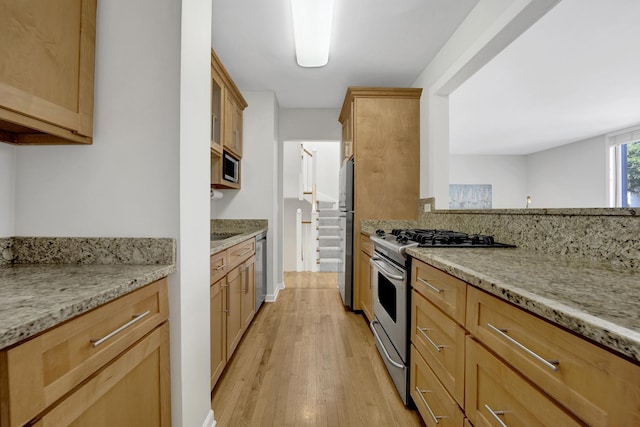 1315 W Webster Ave, Chicago, IL 60614 - kitchen with appliances with stainless steel finishes, light wood-style flooring, and light stone counters