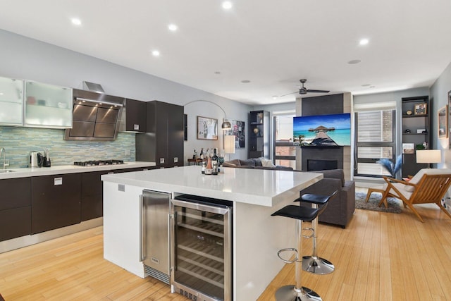 1529 W Chestnut St Unit 102, Chicago, IL 60642 - kitchen with beverage cooler, a breakfast bar area, stainless steel gas stovetop, light countertops, and decorative backsplash