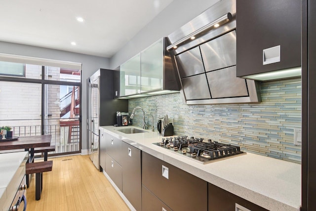 1529 W Chestnut St Unit 102, Chicago, IL 60642 - kitchen featuring stainless steel gas cooktop, backsplash, light countertops, light wood-style floors, and recessed lighting