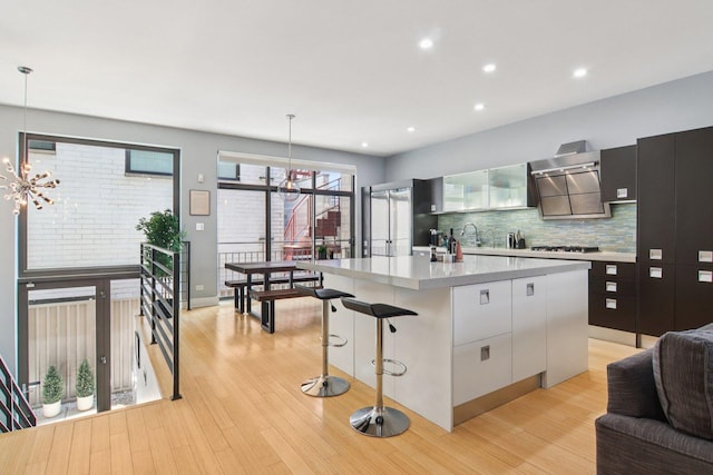 1529 W Chestnut St Unit 102, Chicago, IL 60642 - kitchen with light countertops, a chandelier, decorative backsplash, ventilation hood, and modern cabinets
