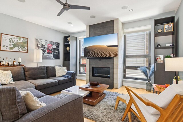 1529 W Chestnut St Unit 102, Chicago, IL 60642 - living area with wood finished floors, a ceiling fan, a tiled fireplace, recessed lighting, and built in features