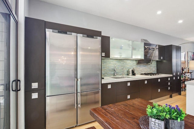 1529 W Chestnut St Unit 102, Chicago, IL 60642 - kitchen featuring high end fridge, light wood finished floors, gas stovetop, decorative backsplash, and light countertops