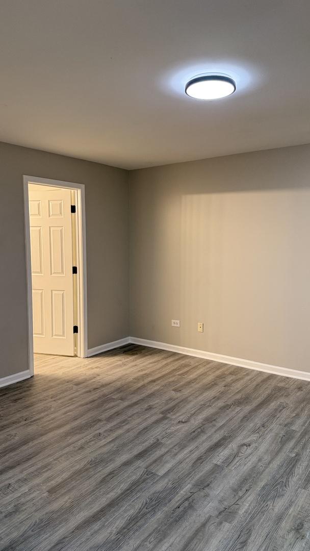 1411 Berta Dr Unit 2N, Crest Hill, IL 60403 - empty room featuring dark wood-style floors and baseboards