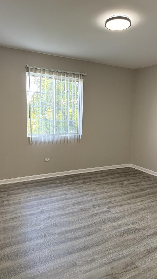 1411 Berta Dr Unit 2N, Crest Hill, IL 60403 - unfurnished room featuring wood finished floors and baseboards