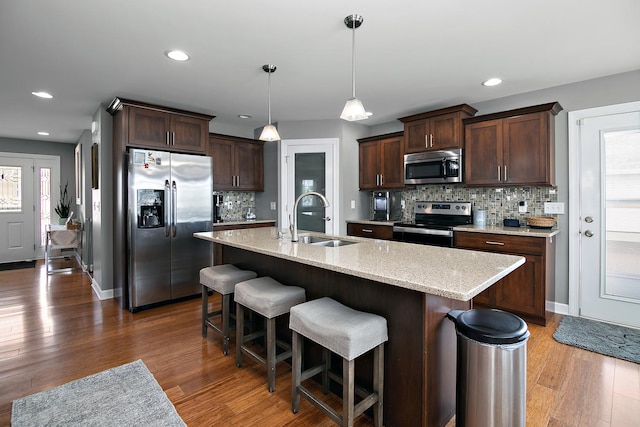 2225 Prairie Chase Dr, Bourbonnais, IL 60914 - kitchen featuring stainless steel appliances, wood finished floors, dark brown cabinetry, tasteful backsplash, and recessed lighting