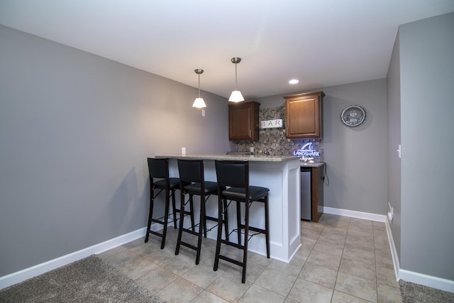 2225 Prairie Chase Dr, Bourbonnais, IL 60914 - kitchen with tasteful backsplash, a kitchen breakfast bar, a peninsula, light tile patterned floors, and hanging light fixtures
