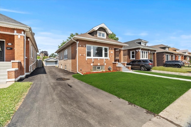 1706 S 9th Ave, Maywood, IL 60153 - bungalow with an outbuilding, brick siding, a front yard, and a detached garage