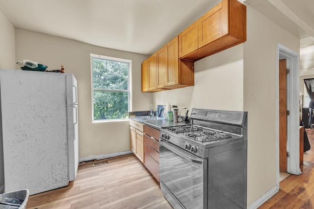 5347 S Racine Ave, Chicago, IL 60609 - kitchen with black gas stove, freestanding refrigerator, and light wood-type flooring
